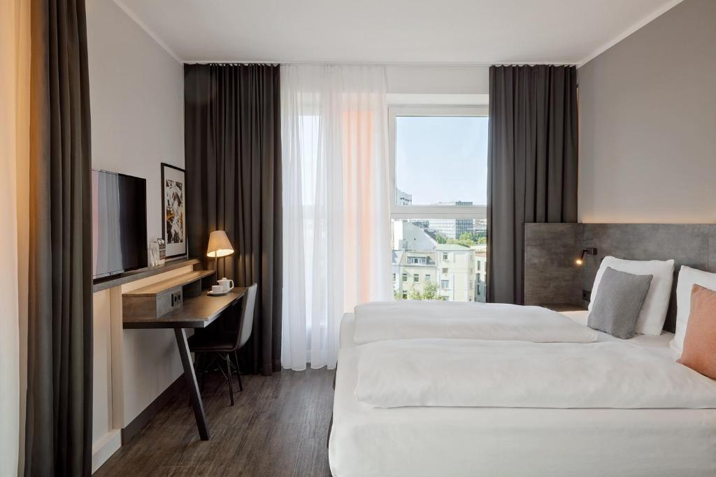 汉堡THE SCOTTY Hotel Hamburg的酒店客房设有两张床、一张桌子和一台电视。