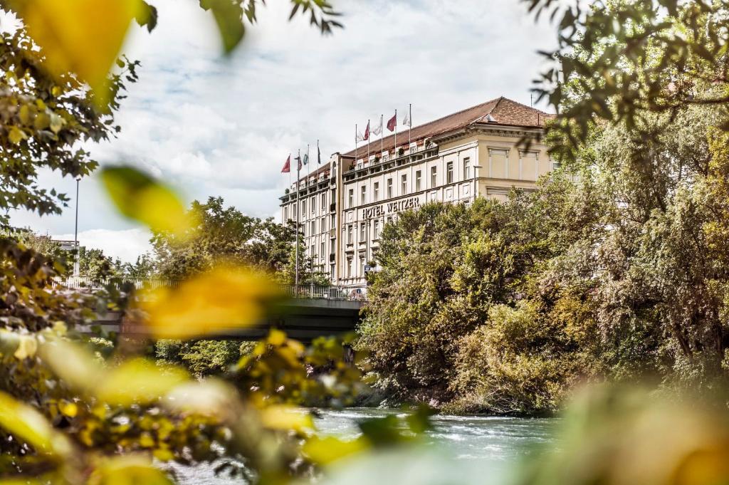 格拉茨Hotel Weitzer Graz - Centre of Graz的一座在河上悬挂旗帜的建筑物