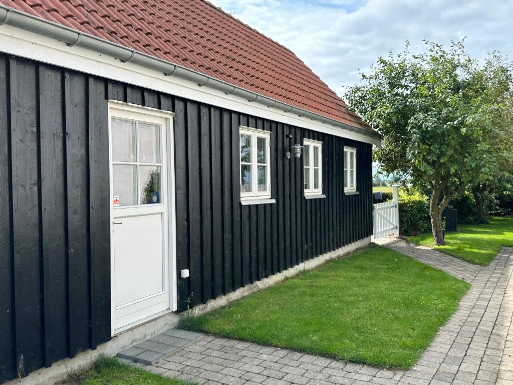 LangøLangø Feriecenter - Sea View的白色的黑白建筑,有白色的门