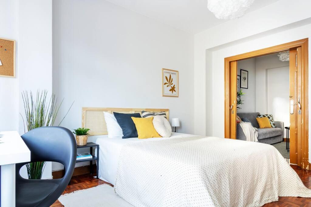 拉科鲁尼亚VibesCoruna - Outeiro 222的白色卧室配有床和蓝椅
