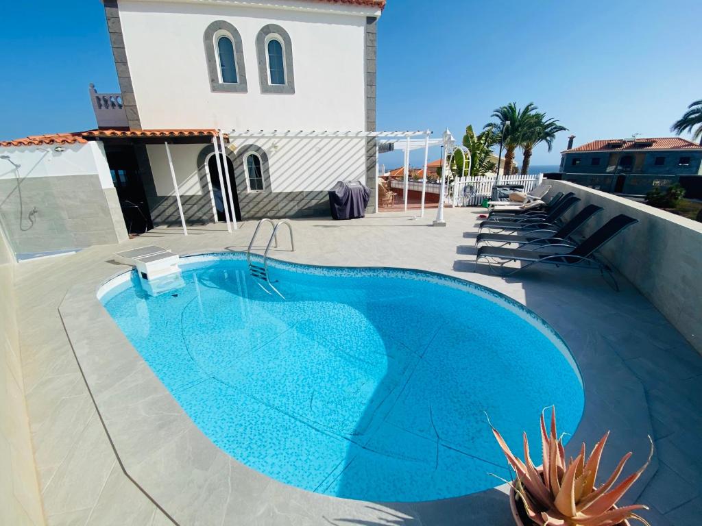 大加那利岛拉斯帕尔马斯Villa Ivanlore的一座蓝色的游泳池,位于一座带建筑的庭院内