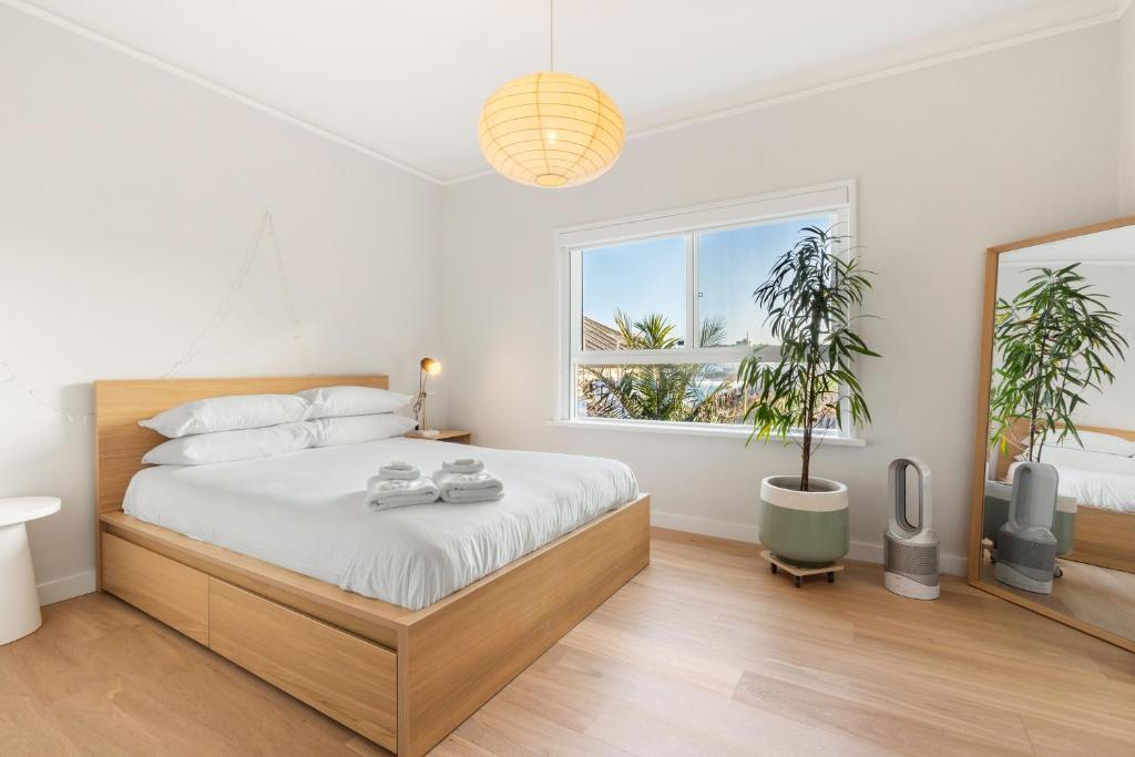 悉尼Sunlit 2BR Coastal Charm Bondi Beach Beach View的一间卧室设有一张大床和一个窗户。