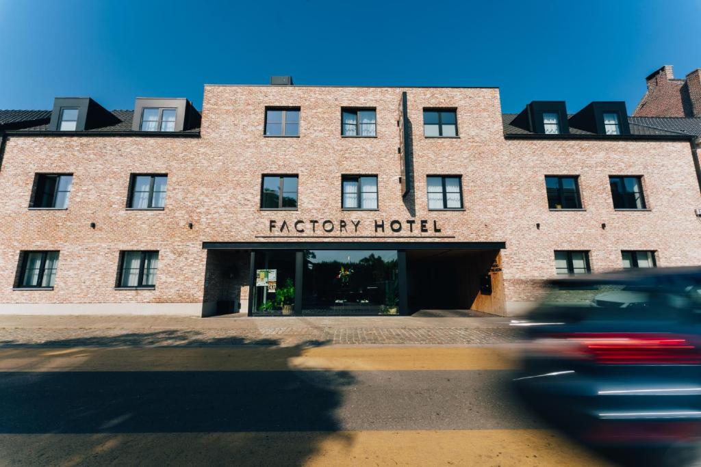 贝弗伦Factory Hotel的红砖酒店,上面有标志