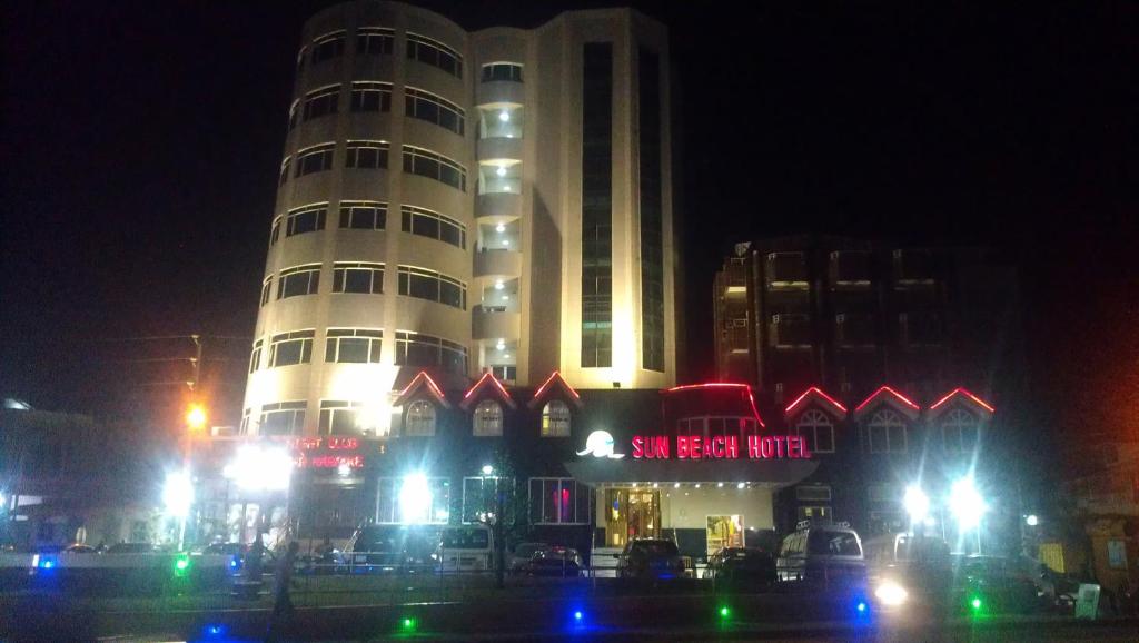 科托努阳光海滩酒店的一座高大的建筑,在晚上有灯在前面