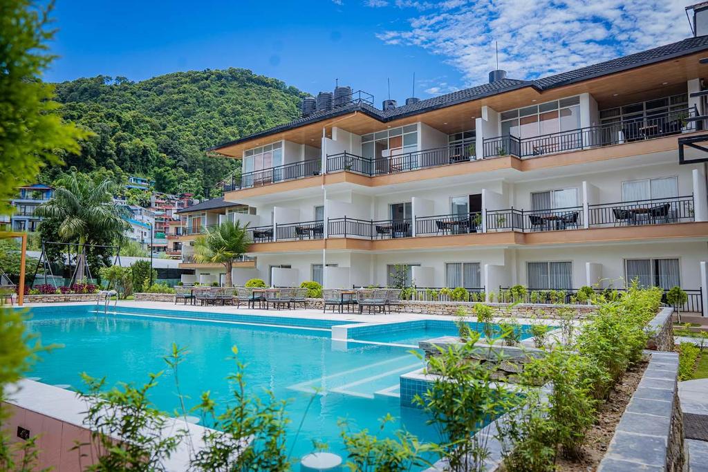 博卡拉Majestic Lake Front Hotel & Suites的大楼前设有游泳池的酒店