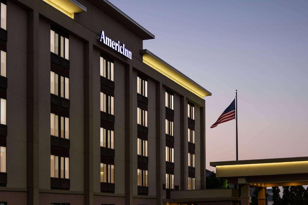 麦迪逊西麦迪逊阿美瑞辛酒店的一座亚马逊建筑,前面有美国国旗