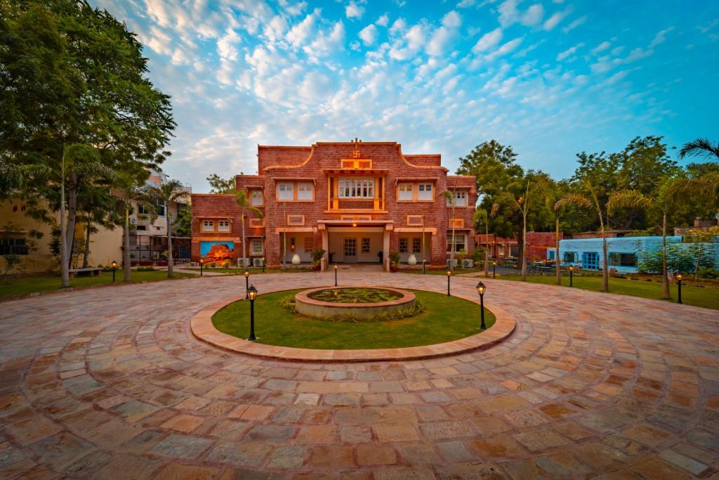 焦特布尔Tree Of Life Bhadrajun House, Jodhpur的一座带圆形车道的大型红砖建筑