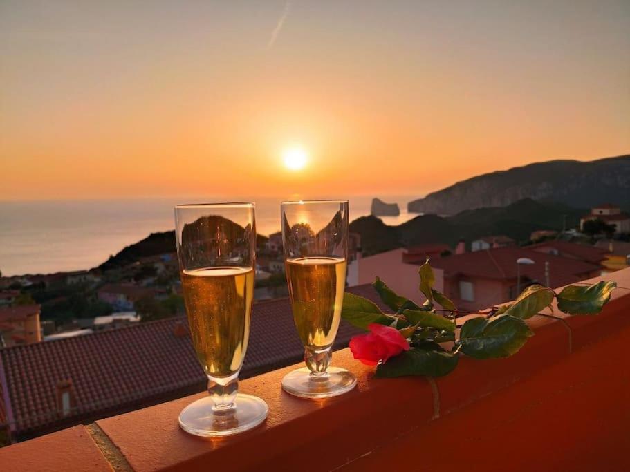 内比达Villa Mariuccia的阳台上的两杯香槟,享有日落美景