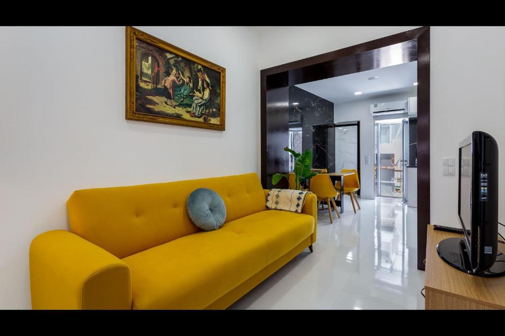 西尔韦斯Stunning Flat With Jacuzzi in Silves by LovelyStay的客厅设有一张黄色沙发,配有电视