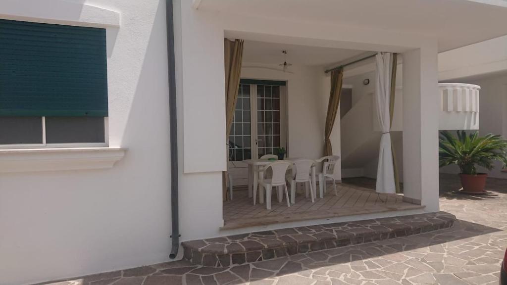 莱乌卡CASA LEUCA的白色的房子,设有配有桌椅的庭院