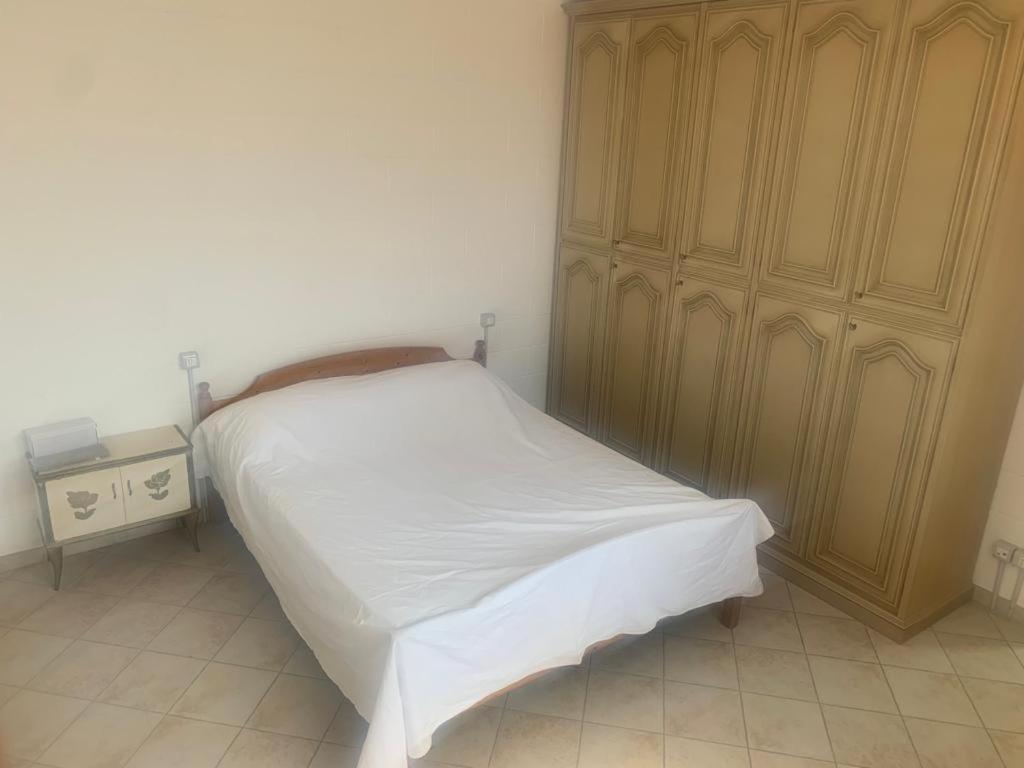 耶索洛Casa Equilium 1的卧室配有白色的床和木制橱柜。