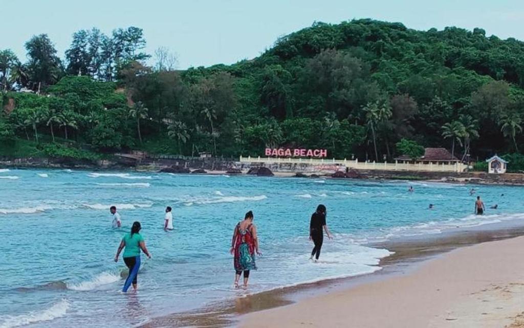 巴加Baga Beach Way的一群人在海滩上水中散步