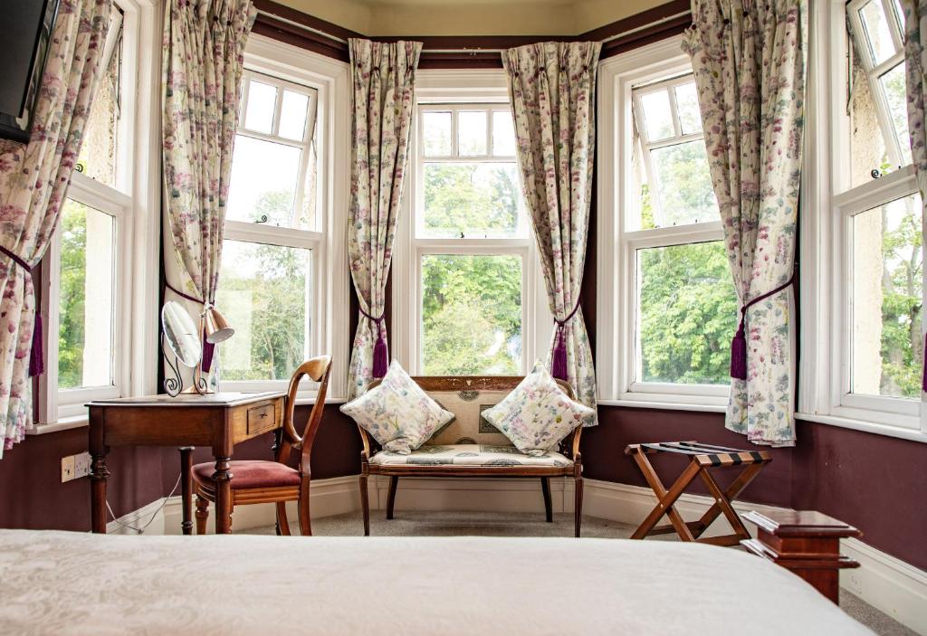 威勒尔Mere Brook House的卧室配有一张床、一张书桌和窗户。