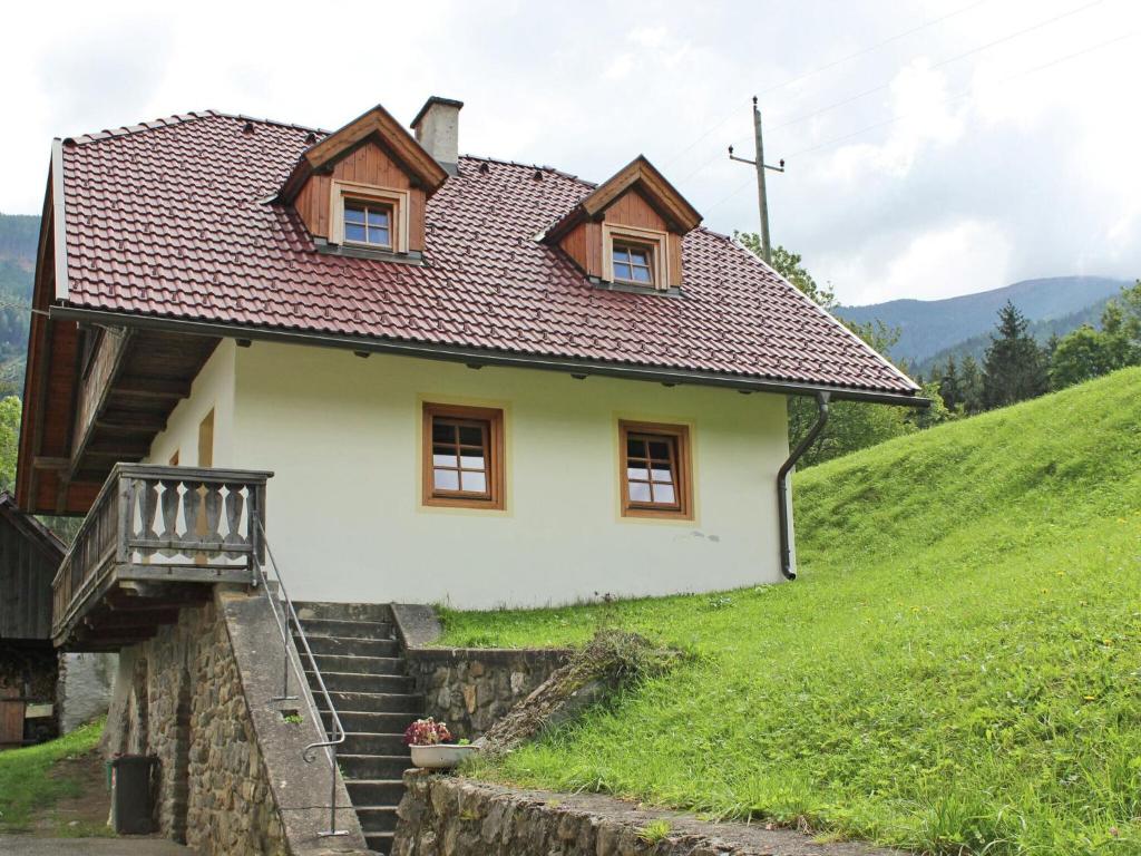 格明德Peaceful Cottage near Ski Area in Gm nd的一座小白色房子,位于山上,设有楼梯