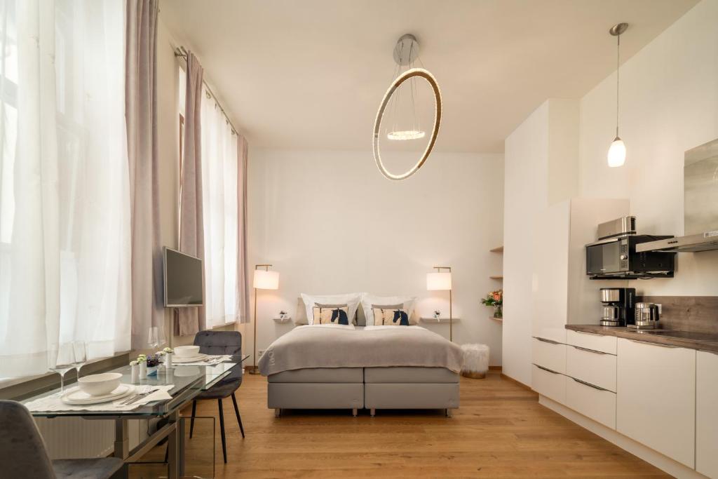巴登-巴登Comfort Apart Baden-Baden的白色卧室配有床和桌子