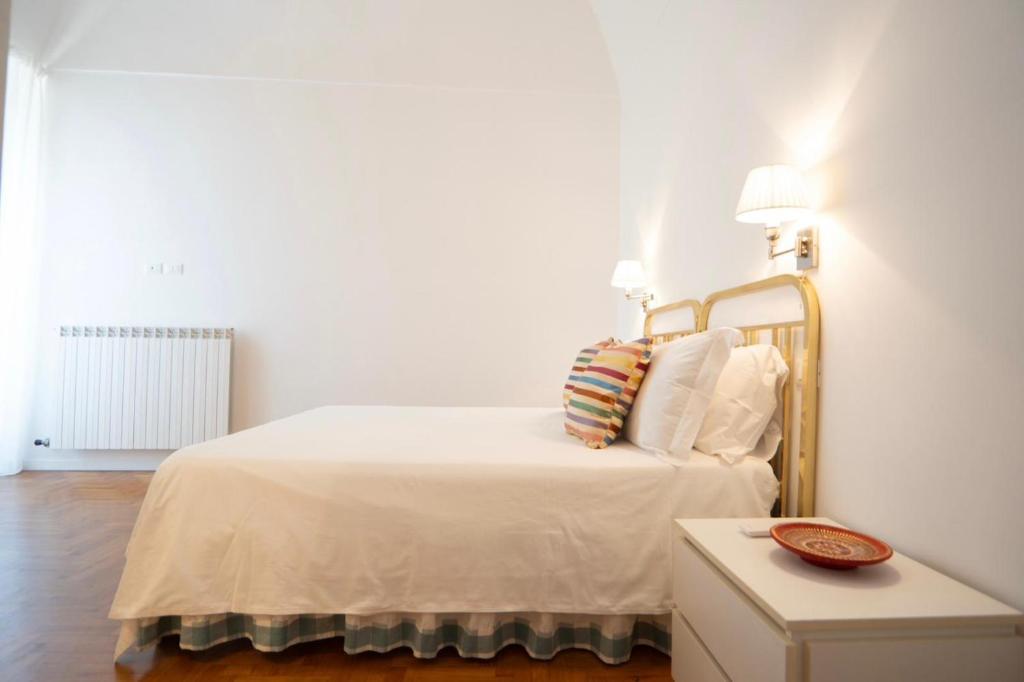阿拉西奥le finestre sul mare的白色卧室配有带白色床单和枕头的床
