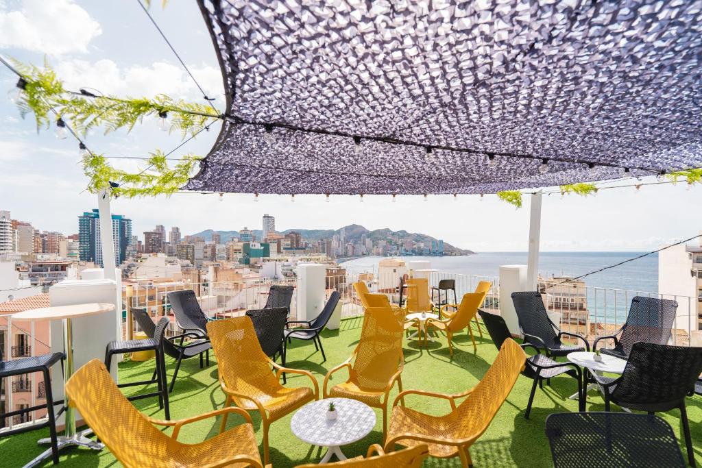 贝尼多姆Hotel Queens - Adults Only的一个带桌椅的屋顶露台,享有城市美景
