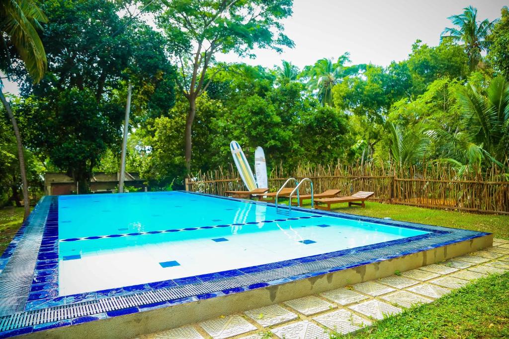 南塔拉拉塔拉拉自由度假村的院子里的游泳池,上面有两个冲浪板