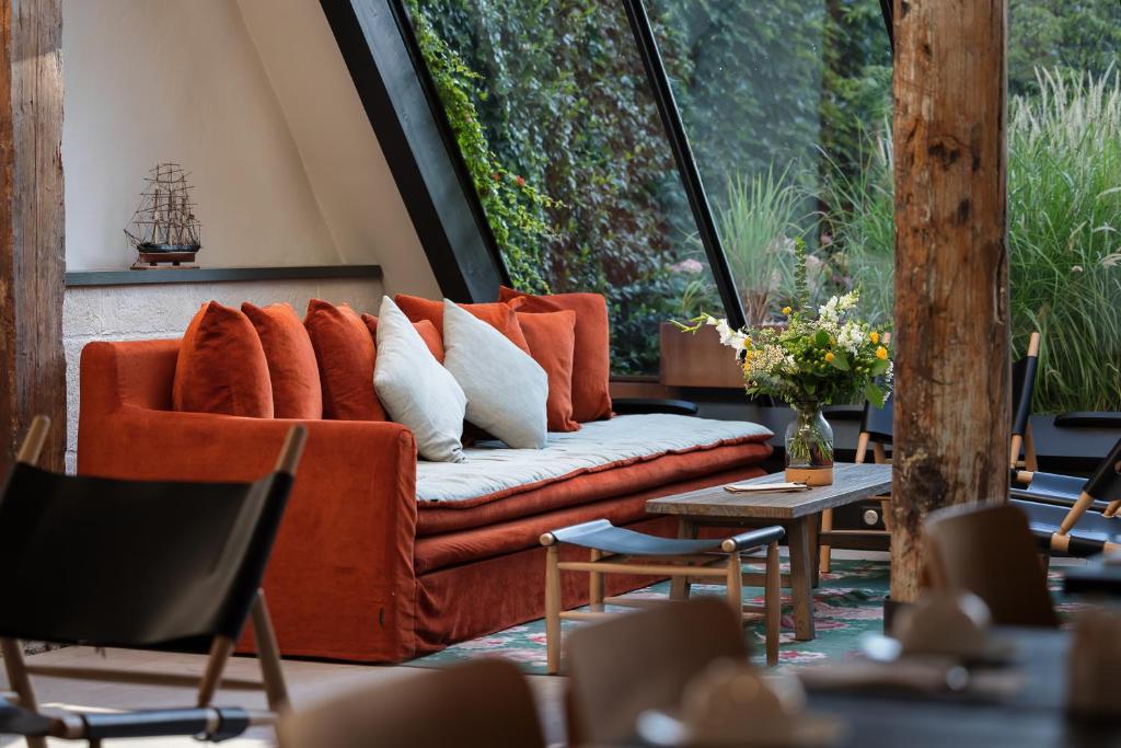 拉罗谢尔圣尼可拉酒店的配有大窗户的客房内的橙色沙发
