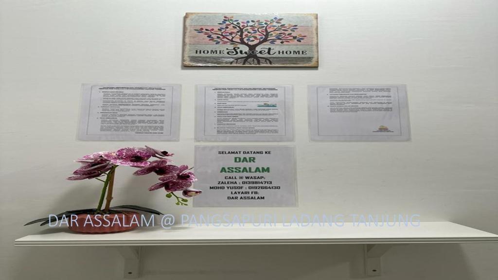 瓜拉丁加奴Ladang Tanjung Dar Assalam Homestay的书架上花瓶里的花