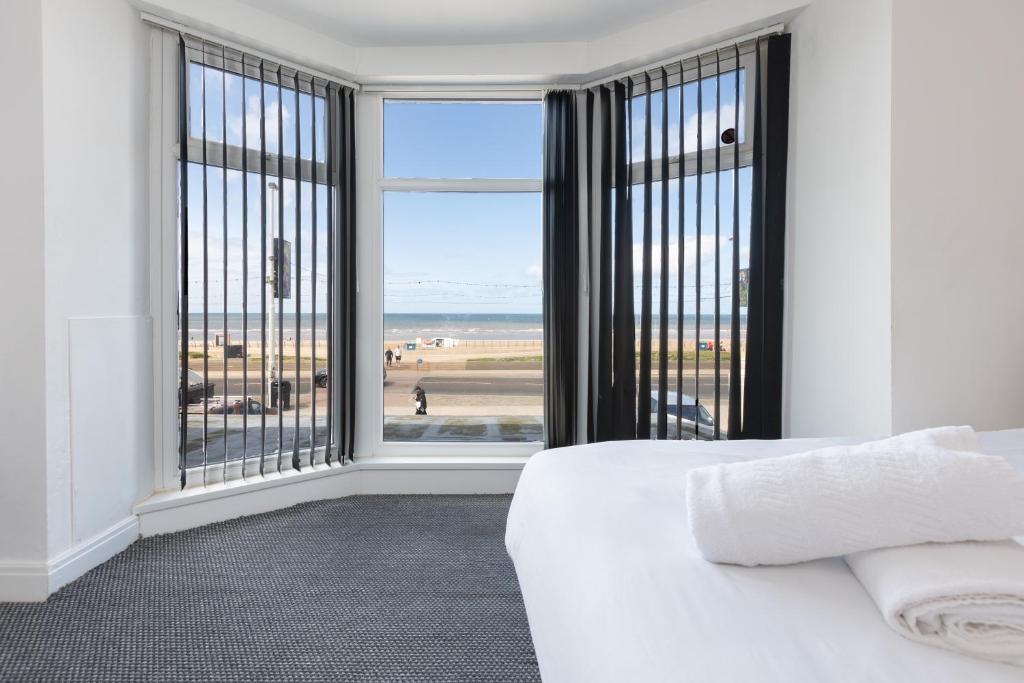 布莱克浦Blackpool Resort Hotel的一间卧室配有一张床,享有海滩美景
