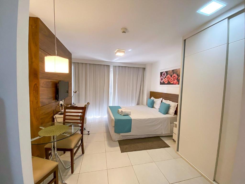 巴西利亚Fusion Acomodação Particular na Asa Norte ao Lado do SHOPPING CONJUNTO NACIONAL com Garagem - 7º andar的酒店客房配有一张床铺和一张桌子。