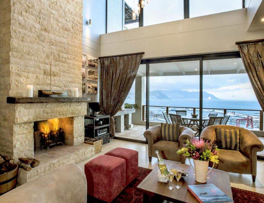 西蒙镇Mariner Guesthouse & Villa的一间带壁炉的客厅,享有海景