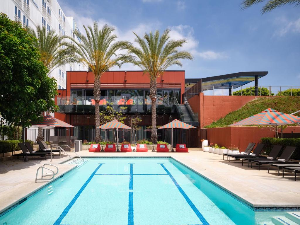 埃尔塞贡多雅乐轩埃尔塞贡多酒店 - 洛杉矶机场的棕榈树建筑前的游泳池