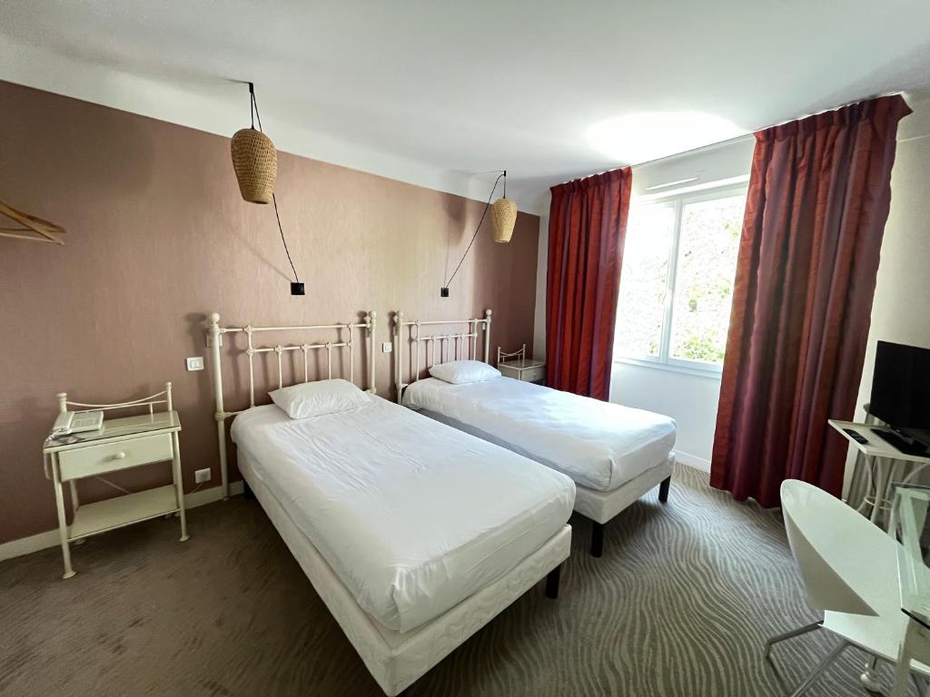 尼奥尔Grand Hôtel Niort Centre的一间卧室设有两张床和窗户。