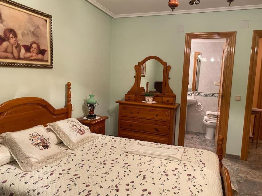 布龙查莱斯Casa Rural María Josefa的一间卧室配有一张床和一个梳妆台,还设有一间浴室