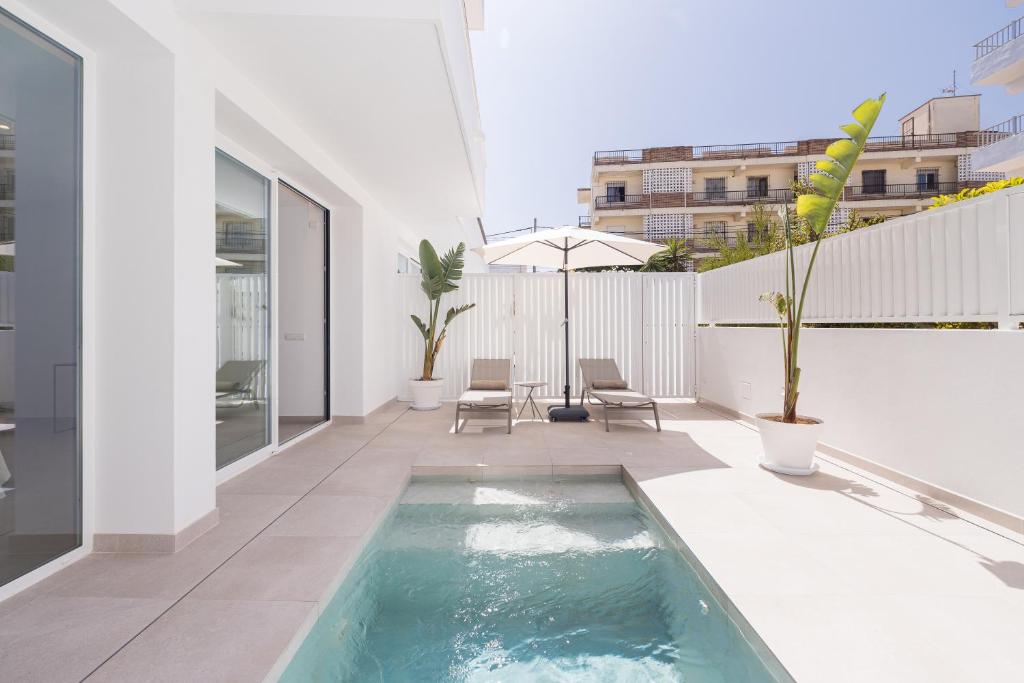 伊维萨镇Bossa Bay Suites with Private Pool - MC Apartments Ibiza的房屋一侧的游泳池