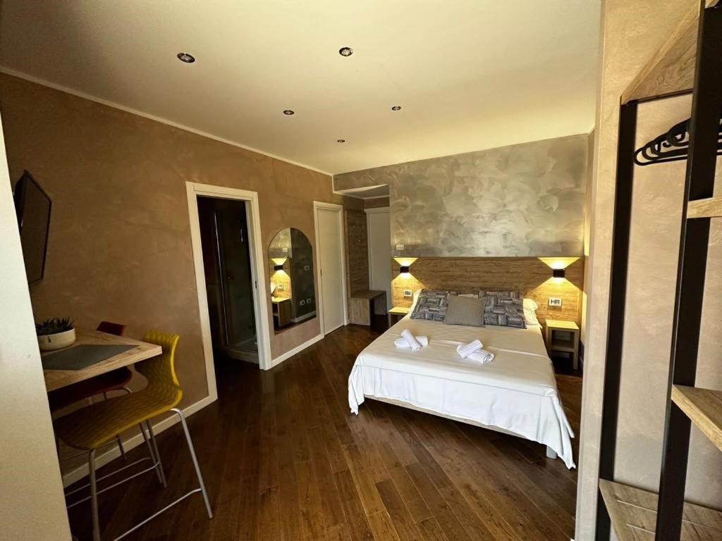 蒙特-坡佐-卡多Casa Catone (affitta camere)的卧室配有白色的床、桌子和椅子