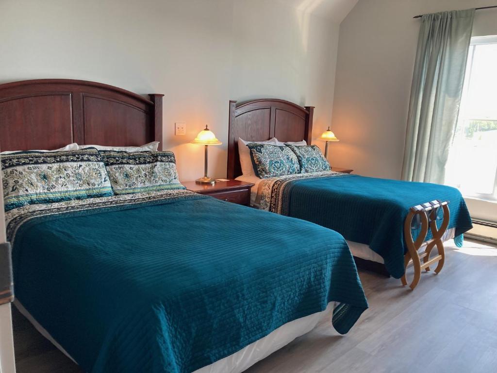 卢嫩堡卢嫩堡埃马姆酒店的配有绿床单的酒店客房的两张床