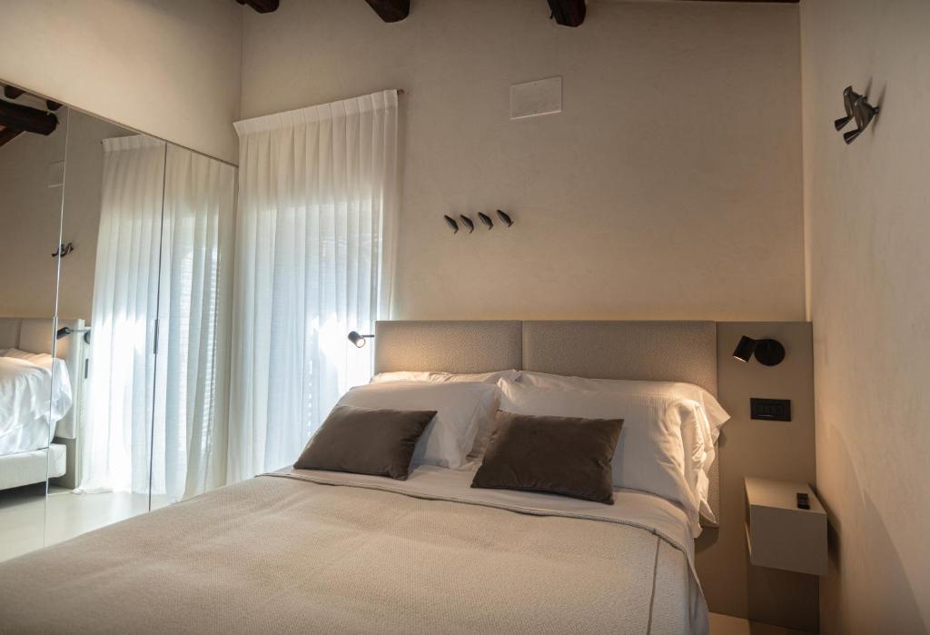 阿西西Xenios Assisi的卧室配有一张带两个枕头的大白色床