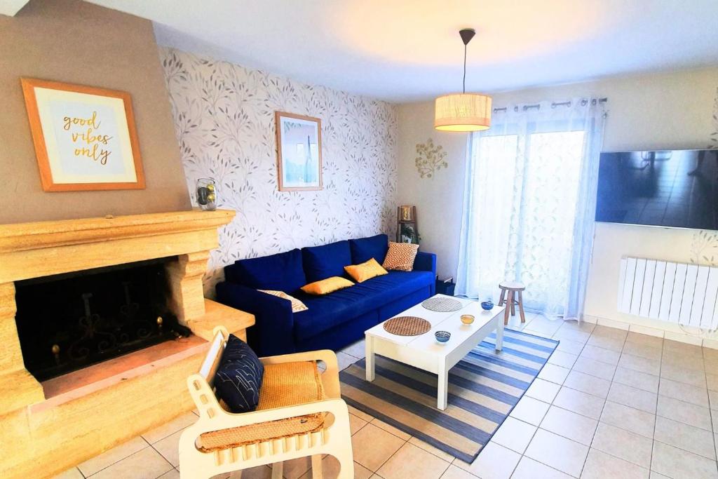迪纳尔Nice house at the entrance of Dinard的客厅设有蓝色的沙发和壁炉