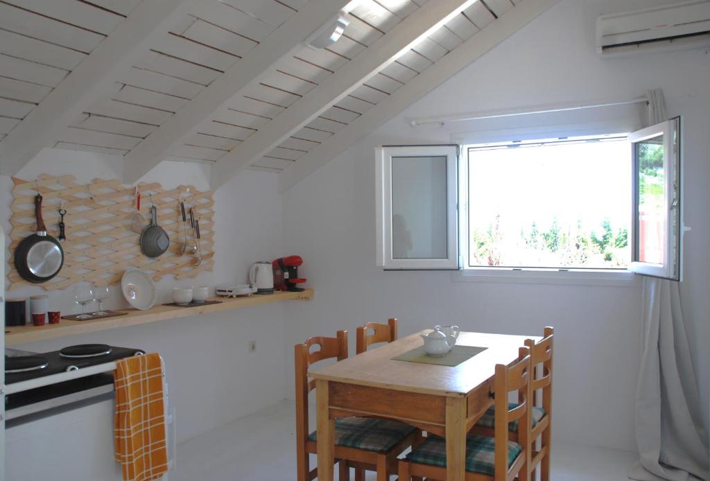 凯特利奥斯Katelios Farm House Loft的白色的厨房配有木桌和窗户