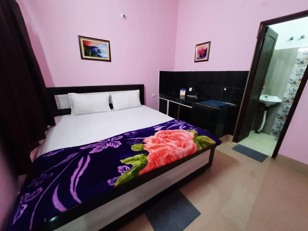 普里Goroomgo Jagannath Inn Puri Near Sea Beach的一间卧室配有一张粉红色墙壁的床