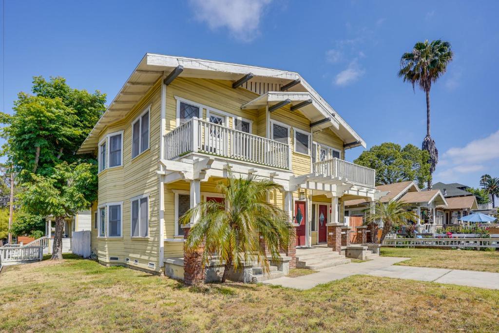 长滩Long Beach Vacation Rental Near Downtown and Beaches的一座黄色房子,前面有一棵棕榈树