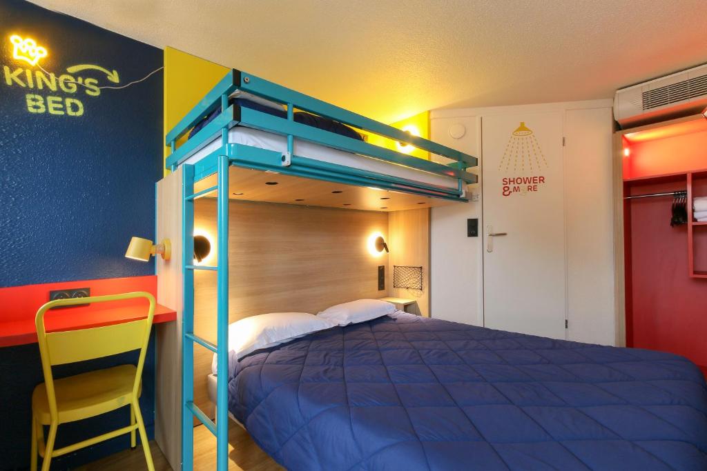 维特罗勒Premiere Classe Marseille Vitrolles Aéroport的一间卧室配有一张蓝色的床和黄色椅子