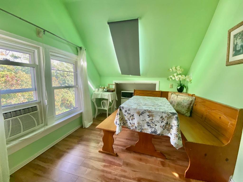 尼亚加拉瀑布Cozy 1-bedroom loft with falls view 4mins to falls的绿色的客房设有桌子和窗户。