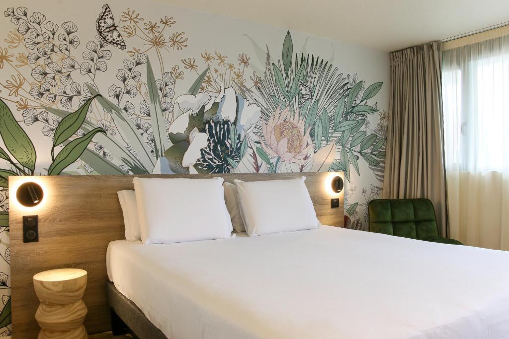 维特罗勒Kyriad Vitrolles Aéroport Marseille的一间卧室配有一张带花卉墙壁的床