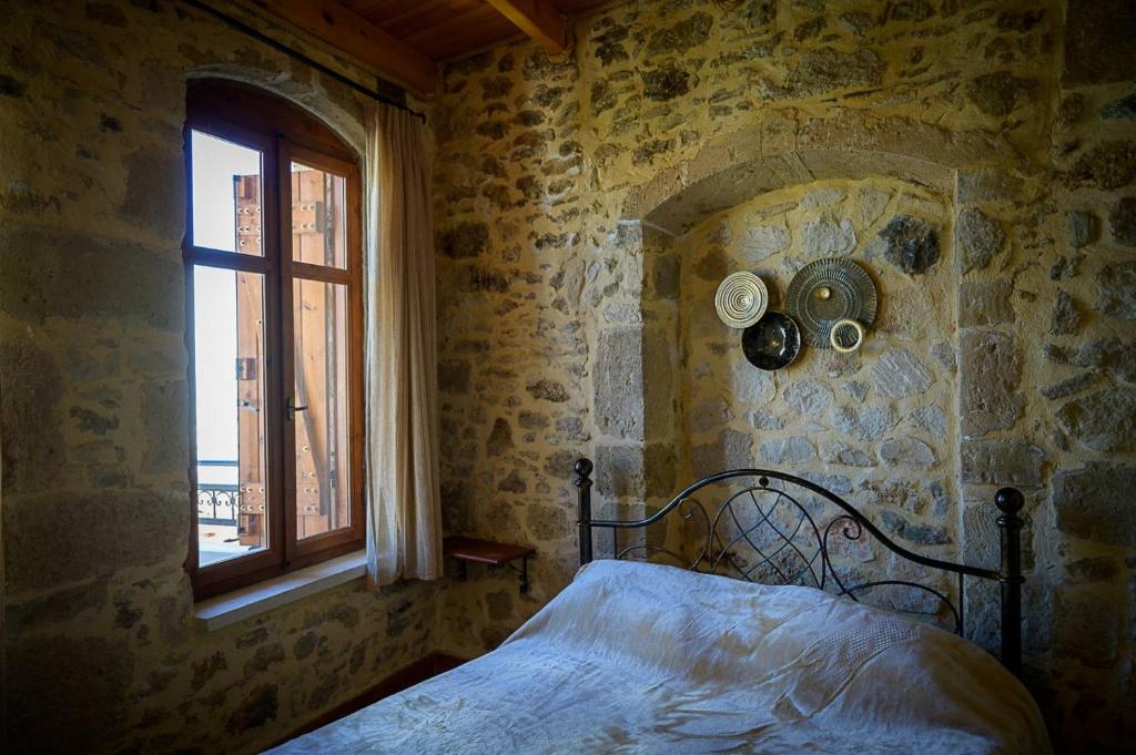 KrousónTraditional Stone Mezonete的卧室配有一张石墙床