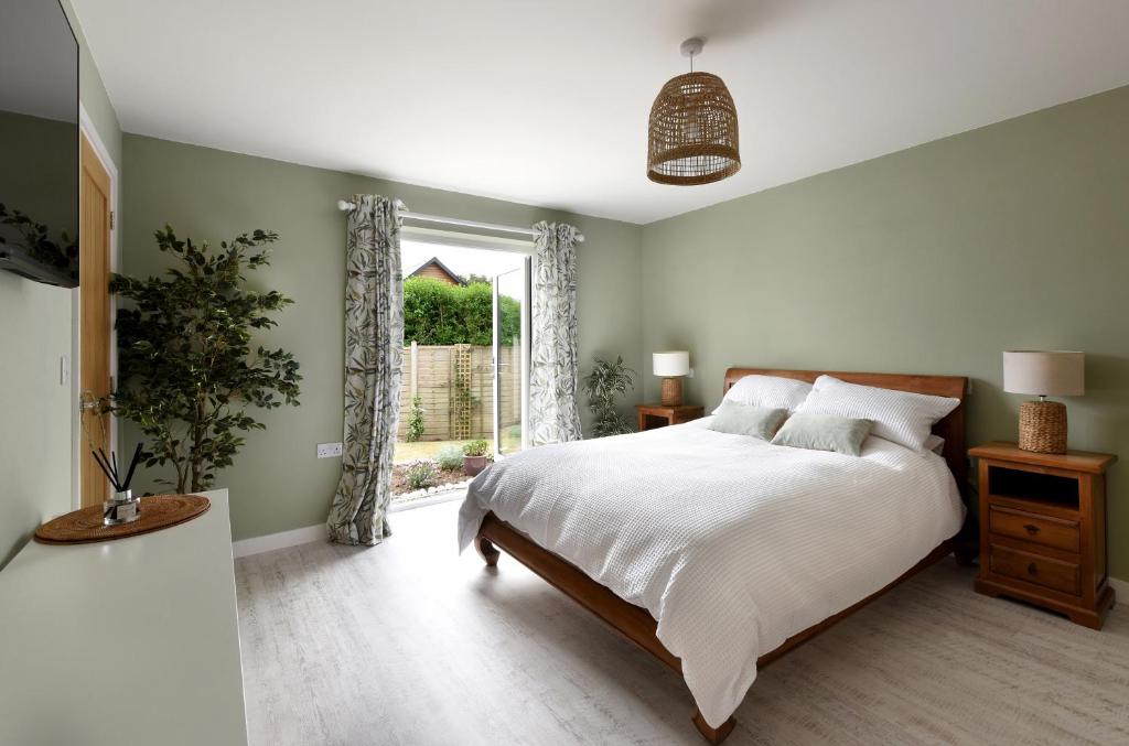 德拉布尔The Garden Room的一间卧室设有一张大床和一个窗户。