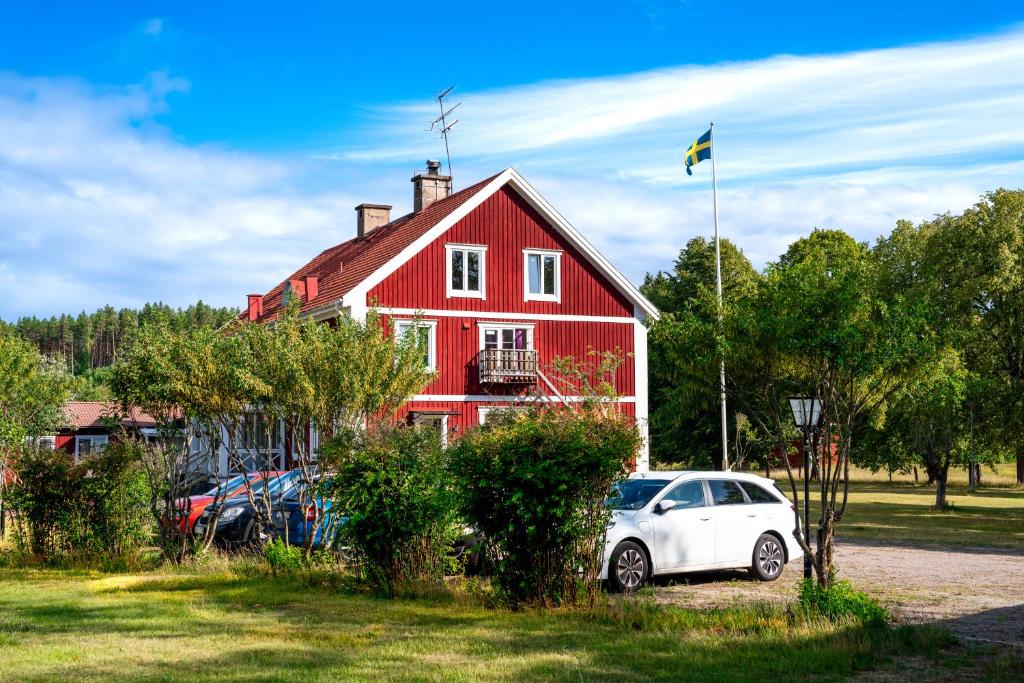 玛丽安娜隆德Hässlebogården Turist & Konferens的前面有一辆白色汽车的红色房子