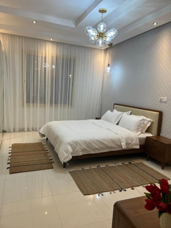 吉达Loft 16的卧室配有一张白色大床和吊灯。