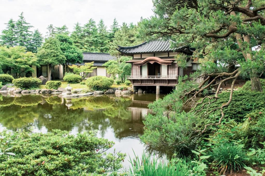 黑部市田中日式旅馆的一个带房子和池塘的花园