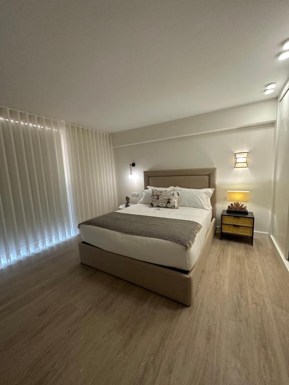 塞洛里库迪巴什图Villa Deluxe - Quinta do Outeirinho的一间卧室设有一张大床,铺有木地板。