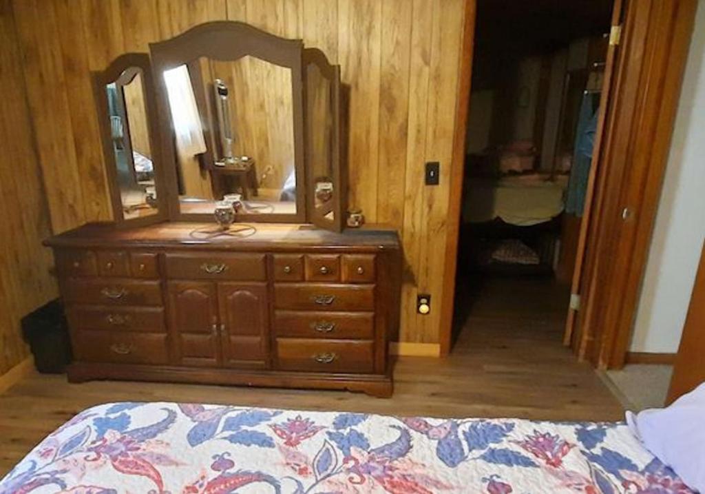 奇夫兰Sandie's Country Bed and Bath的一间卧室配有带镜子的梳妆台和一张床