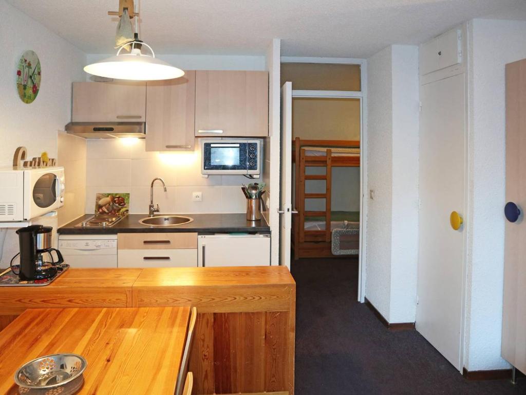 莱索尔Appartement Les Orres, 1 pièce, 4 personnes - FR-1-322-528的厨房配有白色橱柜和木制台面