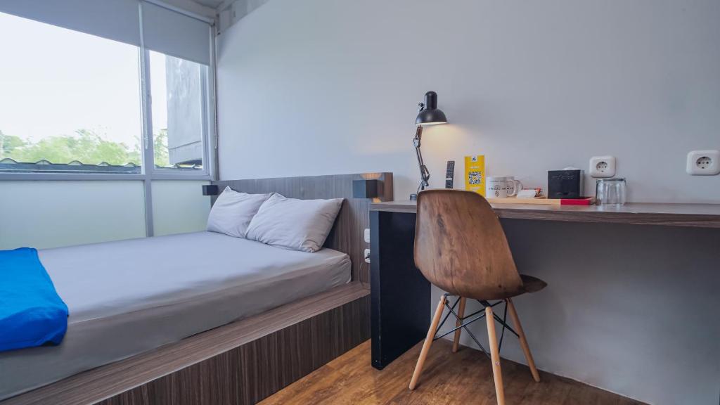 SengkalingMy Dormy Hostel UMM的小房间设有一张床、一张桌子和一把椅子